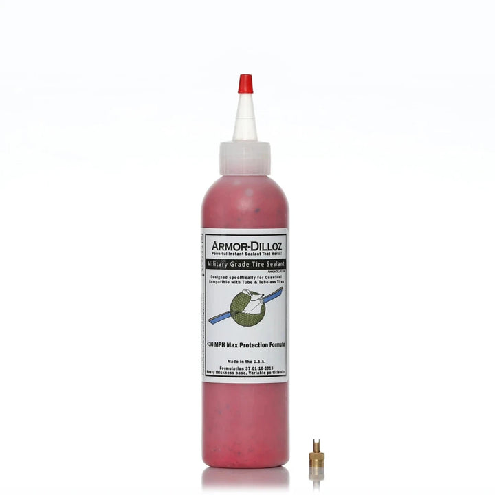 Bottle of red (Maximum Effect) Armor-Dilloz Military Grade Tire Sealant with included valve removal tool, designed for puncture prevention and enhanced durability in electric scooter and bike tyres.