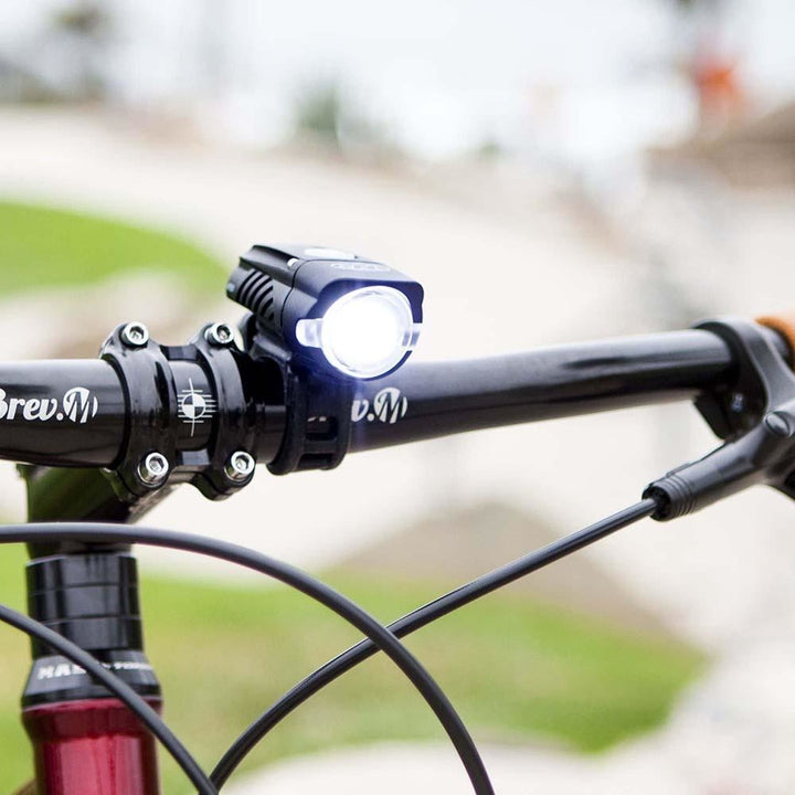 NiteRider Swift 500 headlight securely mounted on bike handlebars, showing bright forward beam during daytime.