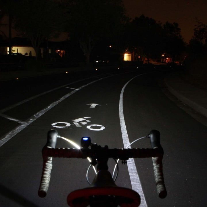 ight road view showing the wide beam spread of the Swift 500 illuminating a bike lane ahead.