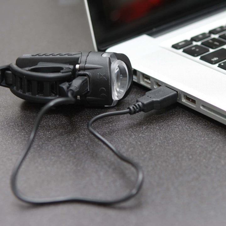 Swift 500 LED light charging via USB cable connected to a laptop, demonstrating easy on-the-go charging.