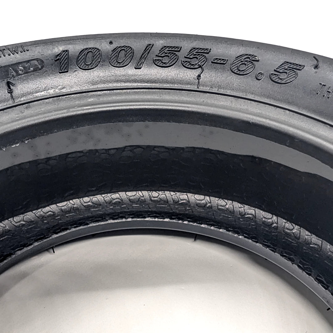 Close up view of the 100/55-6.5 sidewall markings, the tubeless construction and the self-healing layer.