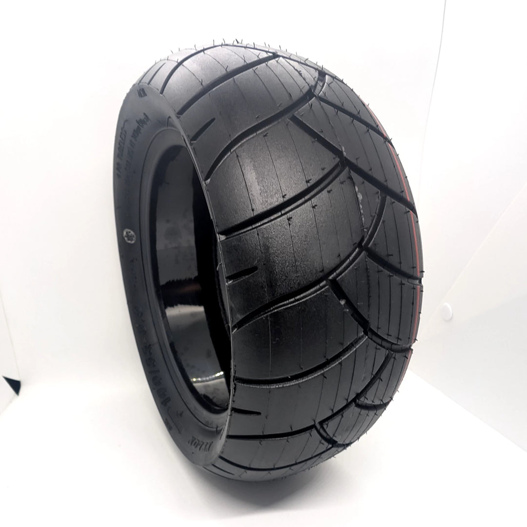 Angled hero view of the Xuancheng 100/55-6.5 self-healing tubeless tyre, showing directional tread and self-healing gel layer inside.