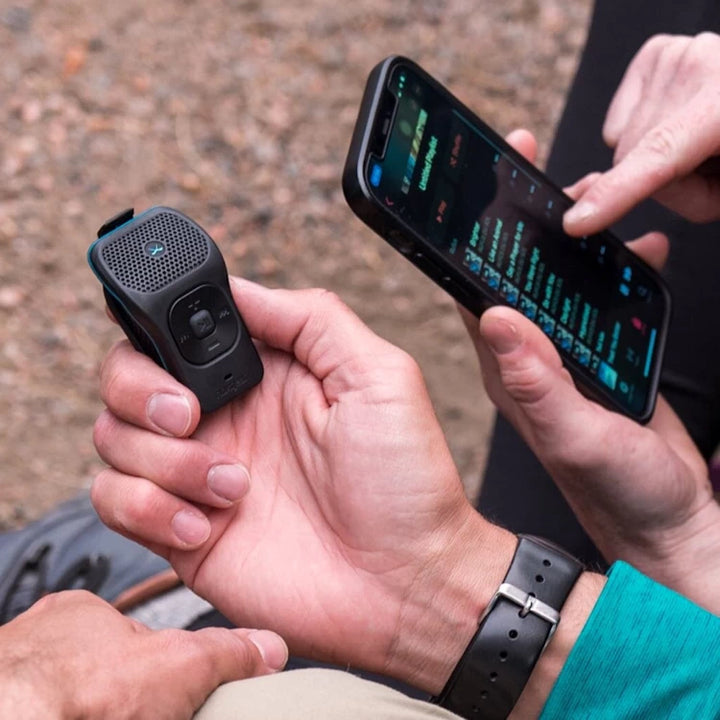 NoxGear 39g Bluetooth speaker in hand alongside a smartphone, highlighting easy connectivity and compact design.