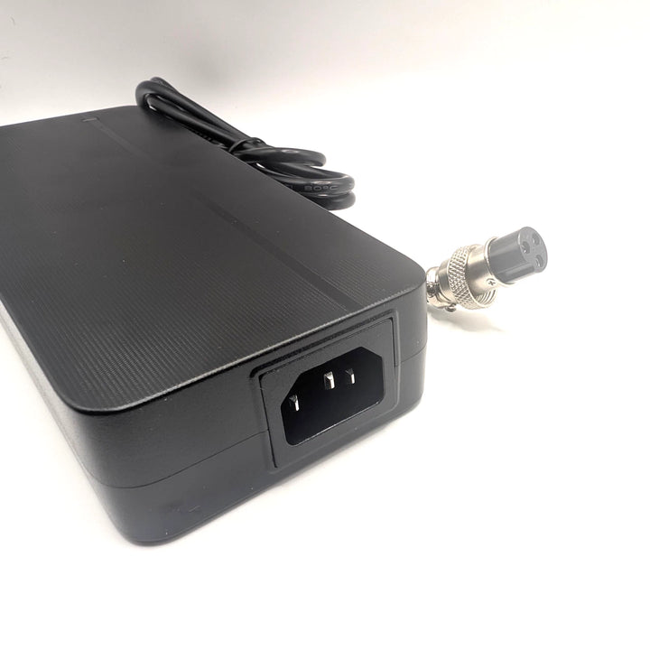 Close-up of the charger’s IEC C14 mains inlet with the GX16-3 charging connector alongside.