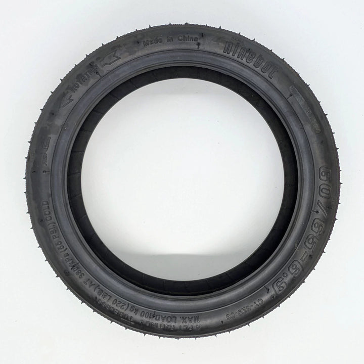 Side profile view of the genuine Ninebot Self-Healing tyre, showing Ninebot brand, 60/65-6.9 sizing and directional arrow on sidewall.  