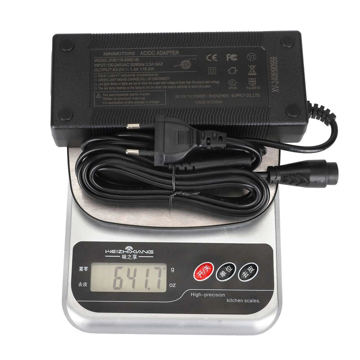 Original Dualtron Ultra 2 83V 1.4A OEM charger with Australian plug and Dualtron LP16-3P connector plug, shown on scales weighing approximately 642g.