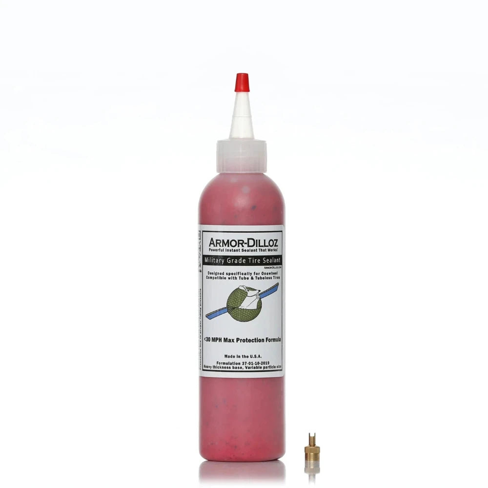 Bottle of red (Maximum Effect) Armor-Dilloz Military Grade Tire Sealant with included valve removal tool, designed for puncture prevention and enhanced durability in electric scooter and bike tyres.