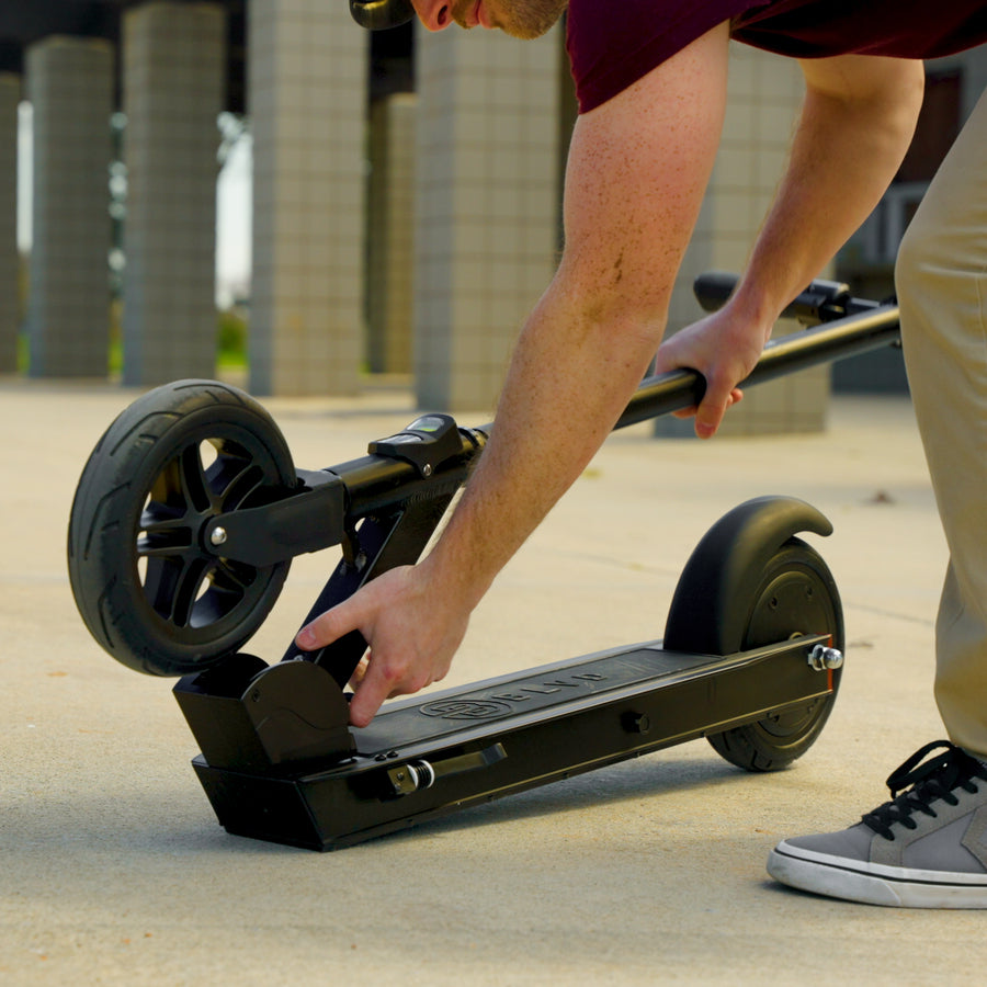 Person unfolding the BLVD Forge electric scooter for easy portability.