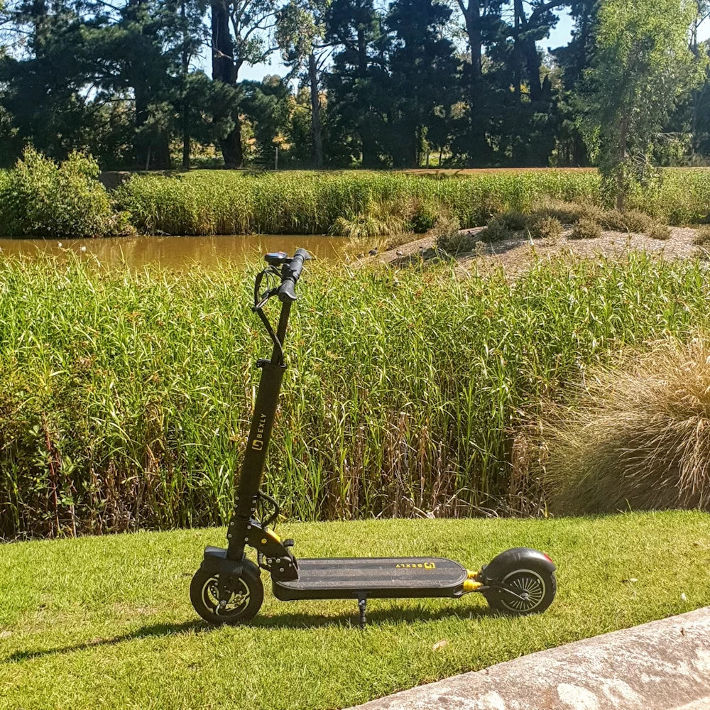 Bexly 9 electric scooter parked by a lush reed backdrop at Heritage golf course, highlighting its outdoor adaptability.