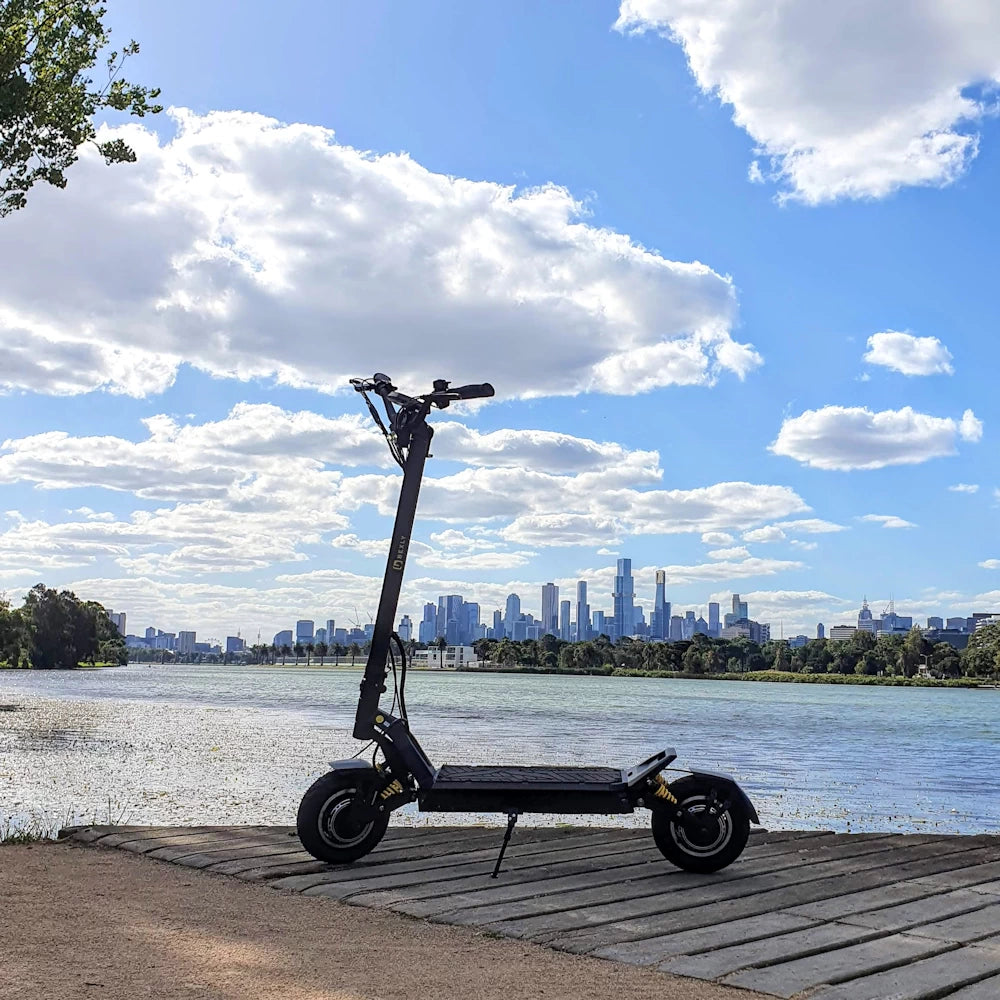 Bexly Blackhawk E-Scooter parked beside Albert Park Lake, with the Melbourne skyline in the background, showcasing powerful design and urban adventure capability. Photo copyright EcoMotion.