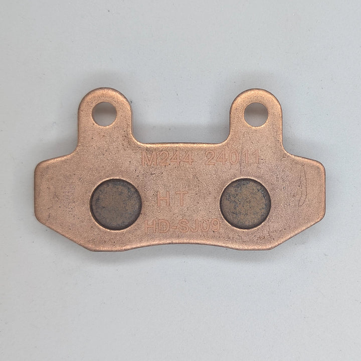 Surron Ultra Bee brake pad backing plate showing M244, HT and HD-SJ09 markings