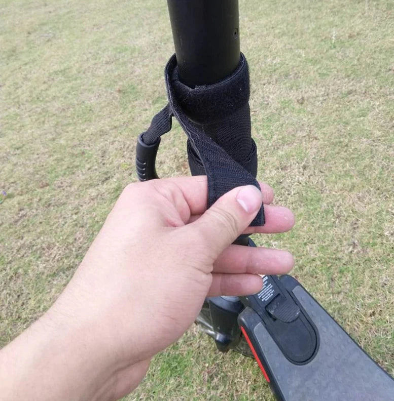 Attaching the portable carrying strap with secure Velcro for a quick installation on electric scooter.