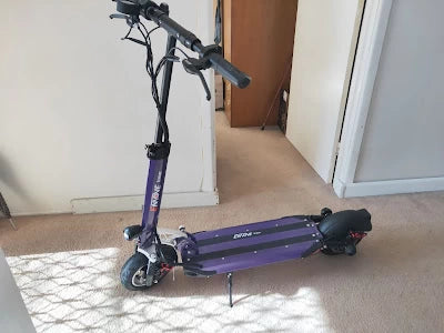 Purple EMOVE Cruiser electric scooter, customer photo by Emily V, highlighting stylish design and comfort for urban commuting and long-distance rides.