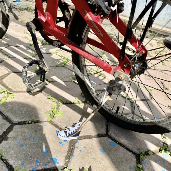 Kickstand of red bicycle fitted with a canvas shoe cover in black and white design