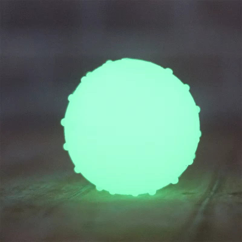 Rubber Luminous Elastic Ball glowing brightly in a dark setting, ideal for nighttime fetch and active play for dogs.