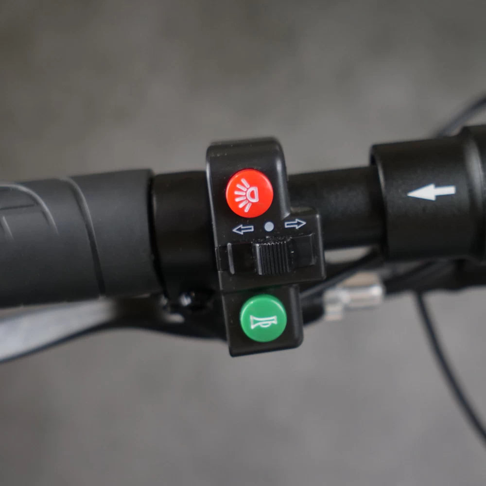 Installed horn, light, and turn-signal switch on EMOVE Cruiser handlebar for scooter safety control.