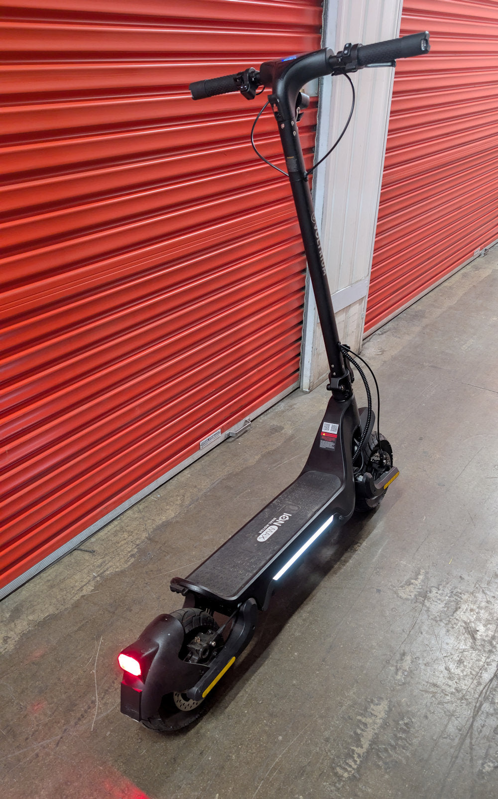 Rear angled view of the Ex-Demo Voltrium ION Max Dual motor electric scooter with side and rear lights activated
