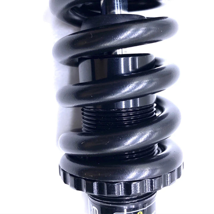 Close-up view of the KS EXA Form 291R shock absorber coil, highlighting the sturdy metal spring and precision threading.