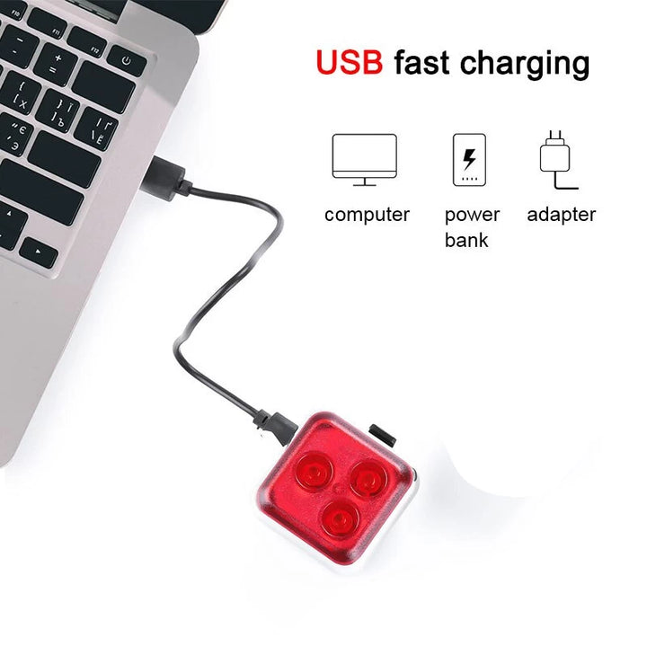USB fast-charging setup for the red rear safety light, showcasing compatibility with computers, power banks, and adapters for convenient charging.