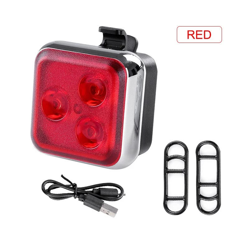 Complete package for the red rear safety light, including the USB charging cable and two rubber attachment rings for versatile mounting options.