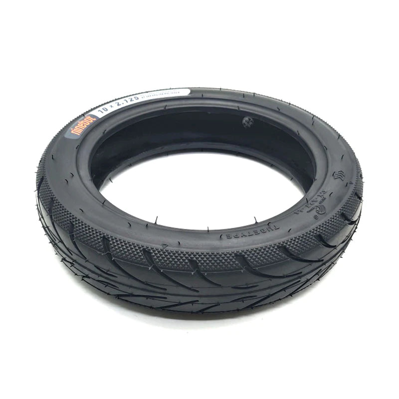 Low angle view of Genuine Ninebot 10x2.125 Tyre, showing directional road tread pattern, with diamond stippled shoulder.