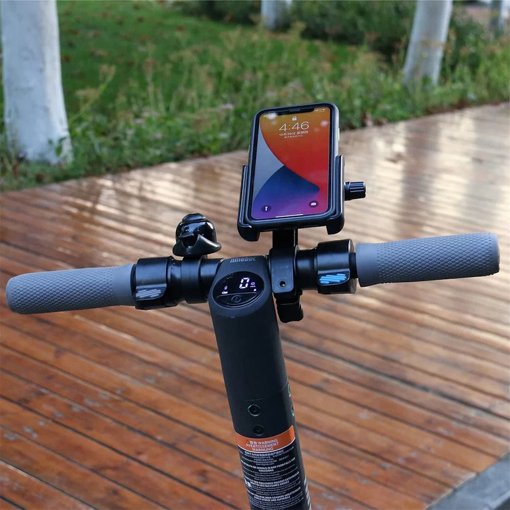 Phone holder securely mounted on a Ninebot electric scooter handlebar with a smartphone in place.