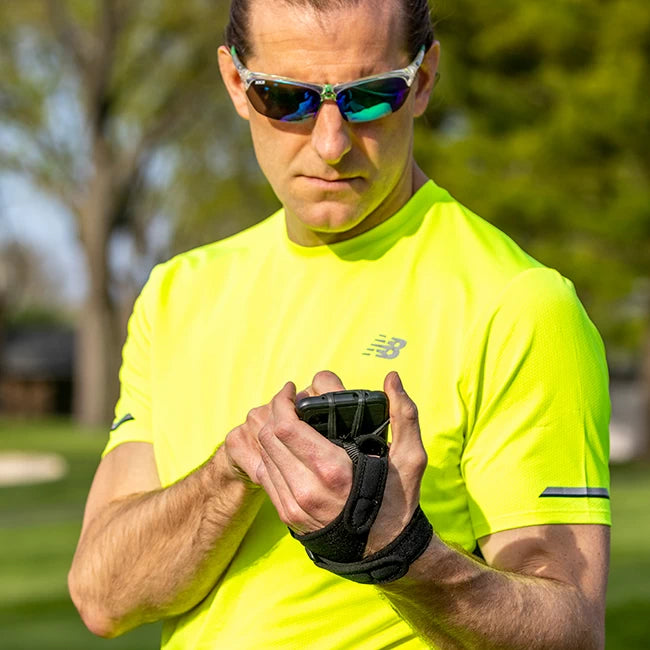 Male runner using phone in NoxGear Phone Holder during workout