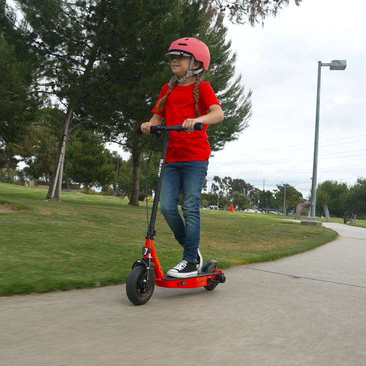 Side view of a child riding the Razor PowerCore Launch electric scooter by a lake, ideal for children aged 8+ years, promoting safe outdoor fun.