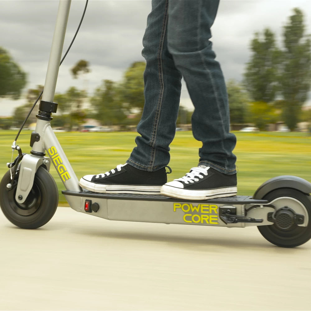 Teenager confidently cornering on the Razor PowerCore Siege Electric Scooter, designed for smooth and agile performance.