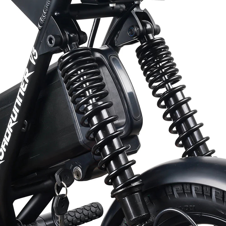 Detailed close-up of the EMOVE Roadrunner V3's rear suspension system, featuring dual coil shocks for a smoother ride.