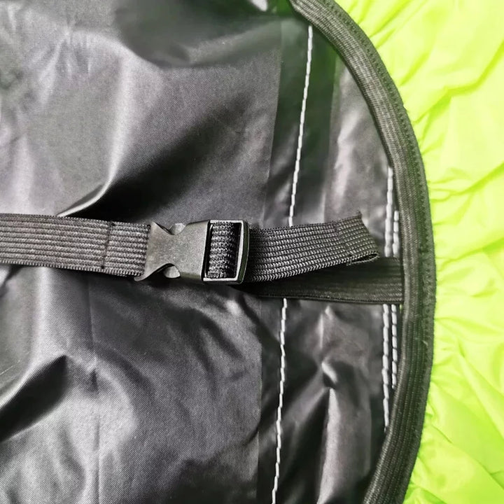 Adjustable strap and buckle system securing the backpack cover in strong winds.