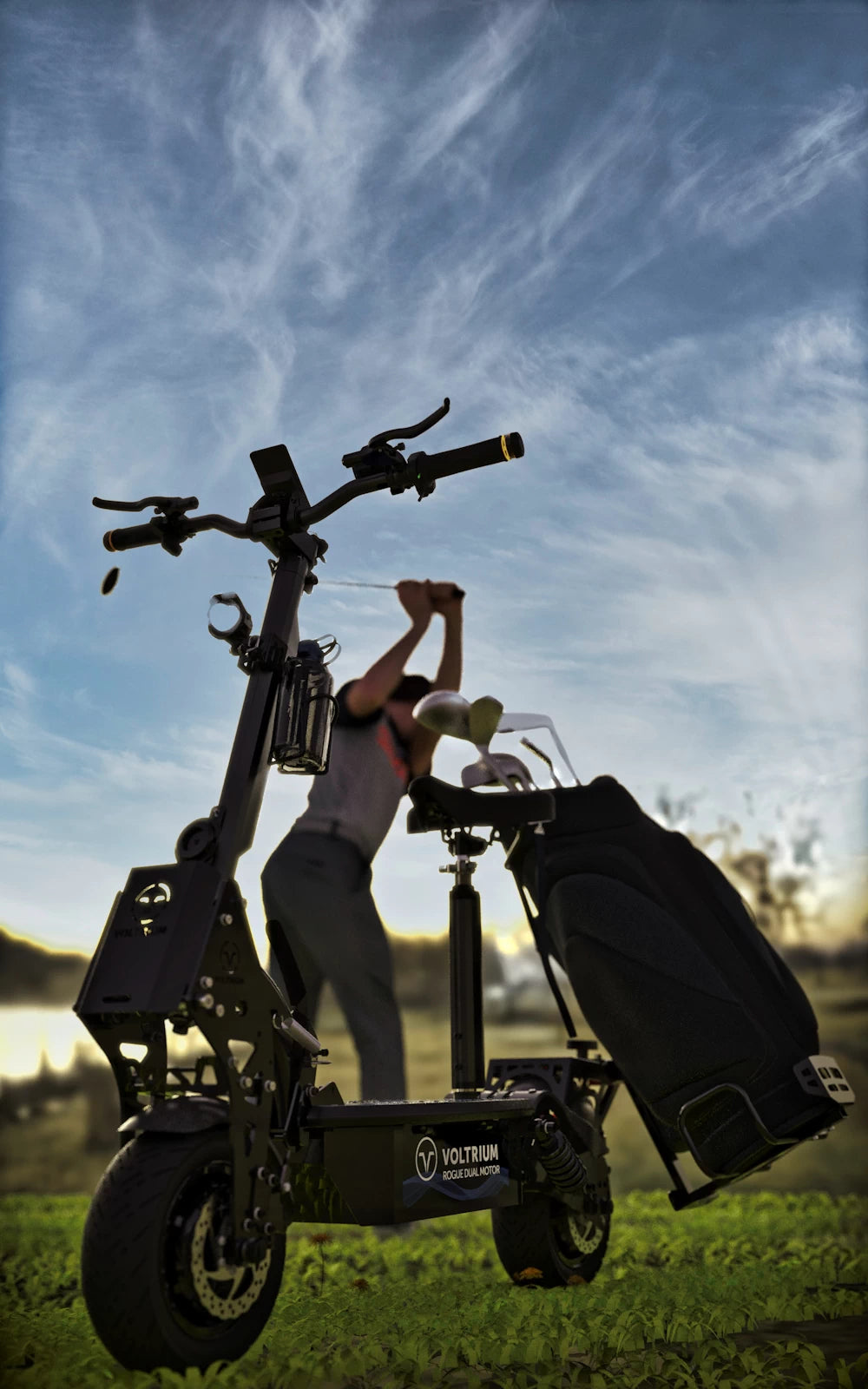 Golf-ready Voltrium electric scooter with mounted golf clubs and golfer in the background, swinging a club. Ride to, from and across the course with style.