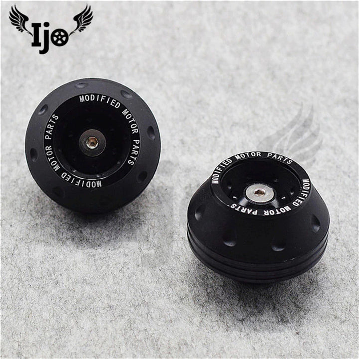 Black electric scooter wheel slider protectors with "Modified Motor Parts" branding. Compact protection designed to shield the rear wheel and motor.