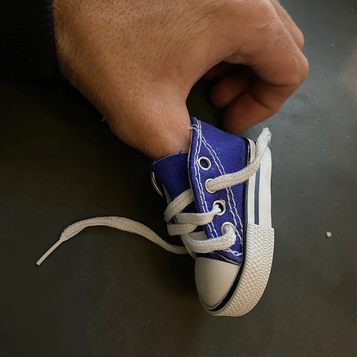 Close-up of thumb holding a blue canvas shoe cover.