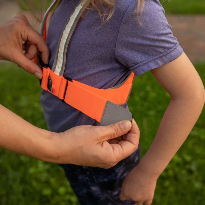 Close-up of an adjustable chest strap being fitted on a child wearing the TracerJR LED Safety Vest.