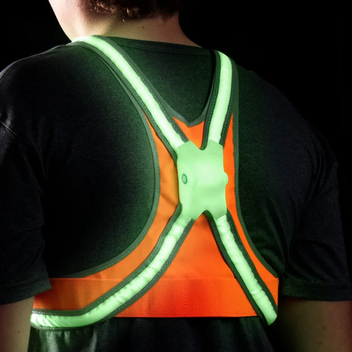 Child wearing the TracerJR LED Safety Vest, rear view showing bright green LED lights glowing in the dark.