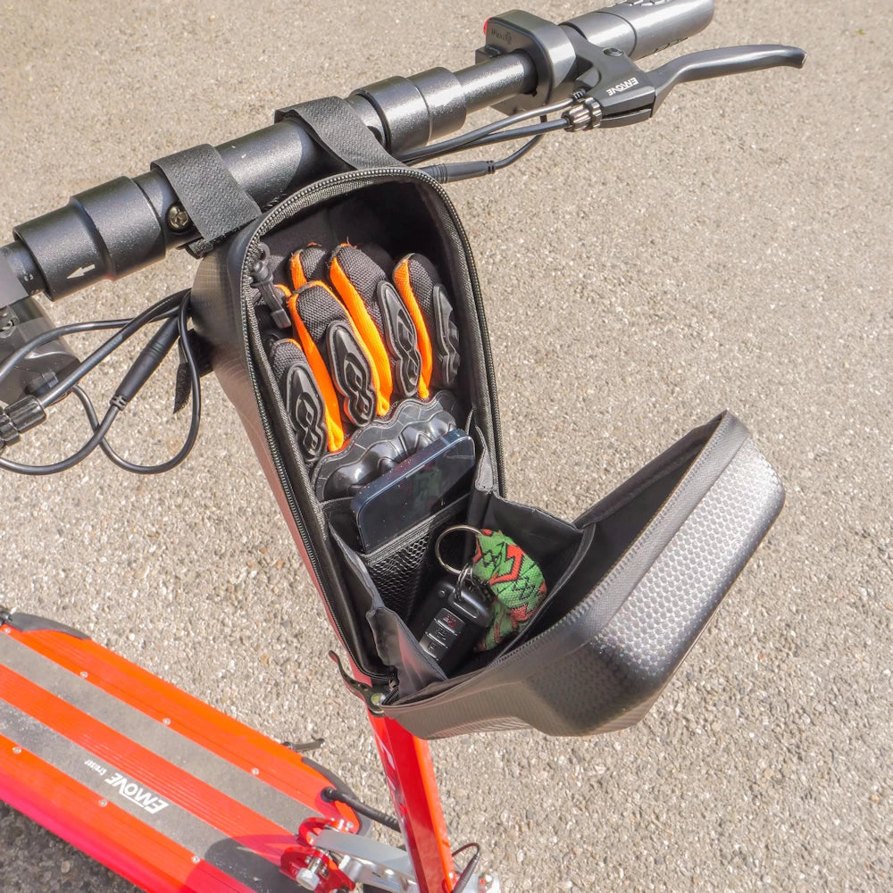 Open EVA pouch mounted on an orange EMOVE Cruiser, highlighting its functional design and practical storage for everyday essentials, such as keys, phone and gloves.