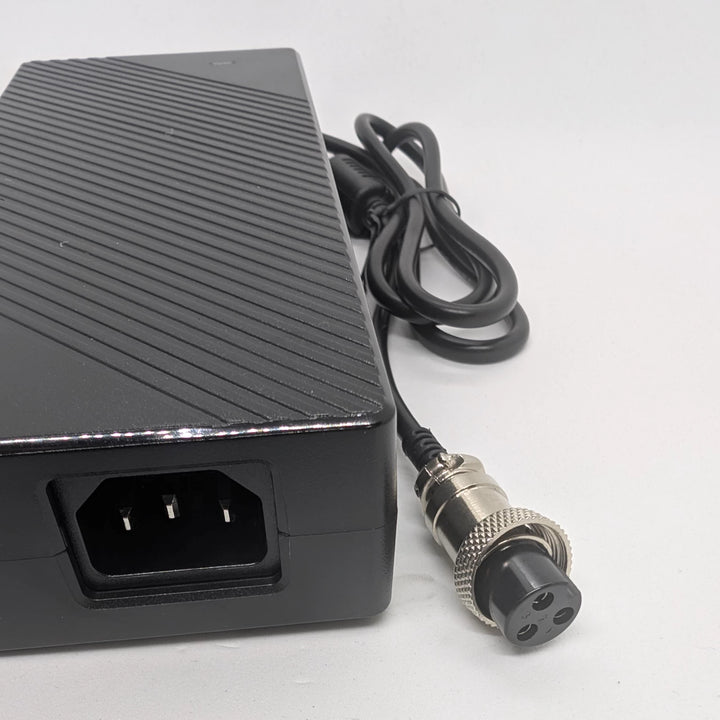 Close-up of IEC C14 power inlet and GX16-3 connector on 67.2V 4A charger