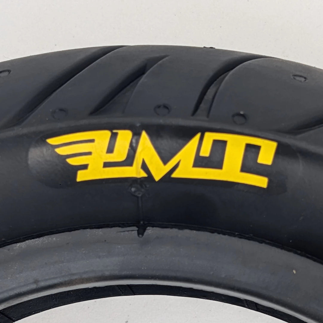 Close up of the yellow PMT logo on the side wall of the PMT 10x3.0 (75/250-R6.0) E-Fire Radial Tyre.